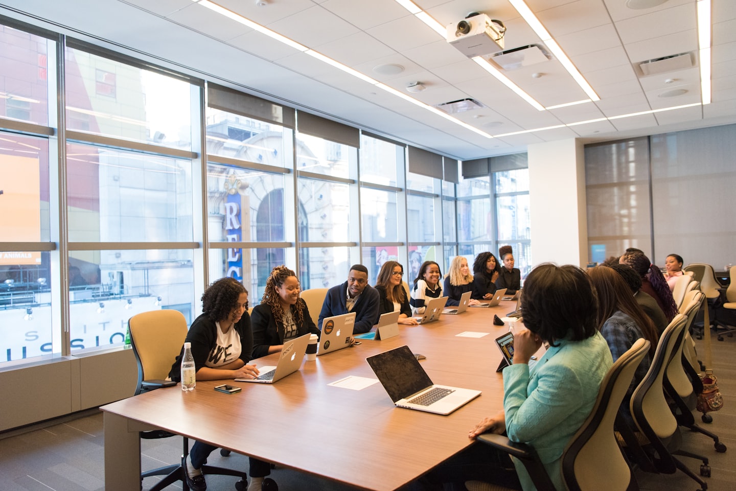 Diverse professionals die samenwerken rond een vergadertafel in een moderne vergaderruimte.
